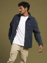 Campera de micropolar gris con detalles en negro en la parte superior y cuello. Tiene cierre frontal, bolsillos laterales con cierre y un bolsillo en el pecho con cierre.