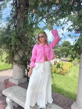 Camisa rosa de lino, de corte crop y mangas largas con puños elásticos.