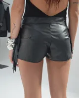 Short negro de cuero sintético con flecos en los laterales.