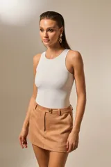 Body sin mangas color blanco, de corte ajustado al cuerpo, con cuello redondo a la base y broches inferiores.