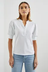 Remera blanca de algodón con mangas cortas abullonadas y cuello henley con tapeta de botones.