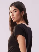Remera blanca de lino, marca Zac & Rachel, con escote en V, abertura con botones y frunce en la parte delantera.