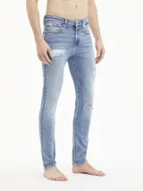 Jeans skinny de tiro bajo, color azul claro vintage con efecto desgastado y rotos en las piernas.