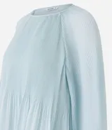 Blusa celeste de crepé con textura plisada, cuello redondo, mangas largas abullonadas y puños ajustados.