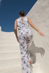 Pantalón de lino blanco con estampado floral azul, de tiro medio y corte semi-oxford con tajos en el ruedo.