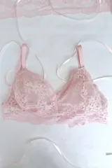 Bralette de puntilla elastizada color rosa pálido, sin aro, con breteles elásticos regulables y espalda fina con broche.