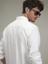 Camisa de manga larga color blanco con bolsillo en el pecho.