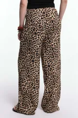 Pantalón de viscosa estampado con animal print de cebra en tonos beige y negro. Presenta cintura elastizada con lazo regulable y pierna recta.