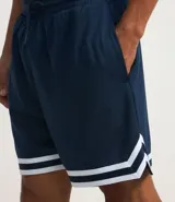 Bermuda deportiva de baloncesto color azul marino con cintura elástica, cordón ajustable y rayas blancas en el bajo. Estampado frontal con la palabra "Boston" y el número 17 en rojo y blanco.