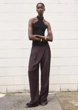 Top negro sin mangas, de diseño entallado, con cuello halter cruzado.