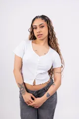 Remera corta de punto canalé color rosa, con escote en V, mangas cortas con volados y cierre frontal con botones.