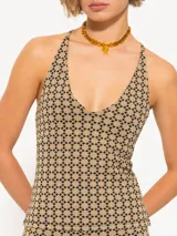 Top color beige con estampado geométrico negro, escote halter y espalda descubierta.