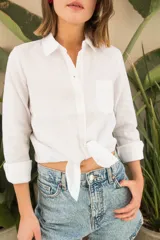 Camisa blanca de lino, de corte clásico, con cuello camisero, manga larga y bolsillo en el pecho.