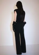 Pantalón de pana negro de corte wide leg, tiro medio, cinco bolsillos y cierre de cremallera y botón.
