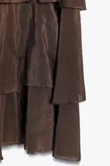 Falda midi color crudo confeccionada en tejido de viscosa, con cintura elástica y volantes en capas.