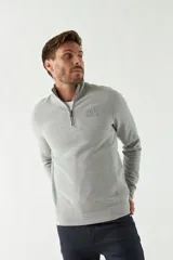 Buzo de felpa azul marino para hombre con medio cierre frontal, logo estampado en el pecho y puños. El modelo mide 1,80 m y usa talle M.