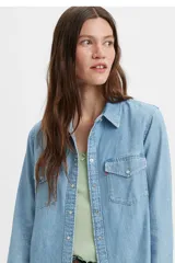 Camisa de denim celeste de manga larga con cuello clásico, cierre frontal con botones a presión, dos bolsillos en el pecho con solapa abotonada y corte recto.