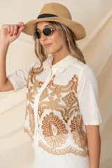 Camisa color marfil de algodón con calado bordado color camel, de corte crop y mangas cortas.
