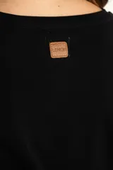 Remera negra de mangas 3/4, corte ajustado y escote redondo.