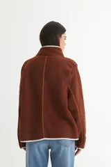 Campera marrón de sherpa doble faz combinada con nylon, cierre frontal y bolsillos cuadrados.