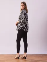 Blusa de gasa estampada en blanco y negro, marca Zac & Rachel. Cuello a la base con escote en V y abertura central con botones. Delantera con detalle plisado. Largo de manga regulable con presilla y botón.