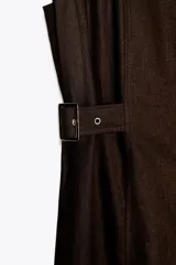 Vestido midi marrón de lino con cuello solapa, escote en pico y sin mangas. Presenta trabillas laterales con cinturón y cierre frontal con botones.