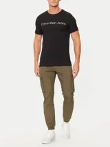 Remera negra de algodón con cuello redondo y mangas cortas. Estampado frontal con el logo "Calvin Klein Jeans" en color dorado.