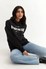 Buzo hoodie negro con estampado frontal de letras blancas con la palabra "OTHERSIDE" y la leyenda "Since 2018" y "MVD - UY".