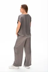 Conjunto deportivo gris compuesto por remera de mangas cortas y pantalón palazzo con cintura elastizada y cordón ajustable.
