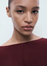 Jersey de punto fino color borgoña, con cuello barco, manga acampanada y diseño oversize.