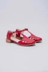 Sandalias bajas negras de cuero con pulsera al tobillo y talón cubierto. Presentan aberturas circulares en la capellada y taco de madera.