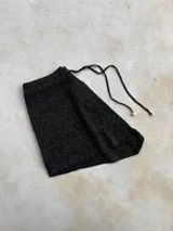 Short tejido de punto color verde esmeralda con lurex, tiro alto y cordón ajustable en la cintura.