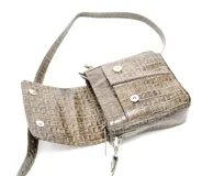 Bandolera mediana color oliva con patrón texturizado, confeccionada en cuero. Presenta cierre con solapa y botón magnético, además de un cierre de cremallera interior visible. Correa ajustable y herrajes plateados.