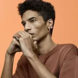 Caravana de botón con cristal con talla de pera color lila, engarzado en metal dorado con cristales color champagne.