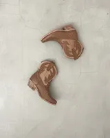 Botas cortas negras de cuero con bordados blancos estilo cowboy.