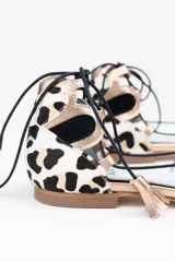 Bailarinas con estampado animal print blanco y negro, con detalles en dorado y cordones de algodón negros con borlas de ante. Incluyen plantilla de piel y plantilla extra de lana intercambiable. Diseño y fabricación 100% española.