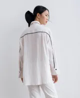 Camisa negra de lino con corte recto, cuello clásico, mangas largas y abertura en los laterales.