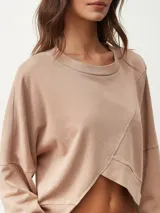 Buzo corto color beige con cuello redondo y mangas largas.