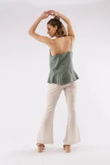 Pantalón cropped beige de lino con tajos frontales y calce ajustado.