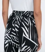 Pantalón pijama fluido de viscosa con estampa geométrica en blanco y negro. Tiene cintura media con ajuste de cordón con puntera metálica, bolsillos y prega frontal.