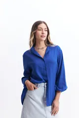 Camisa azul de manga larga con cuello mao, corte holgado y cierre frontal con botones.
