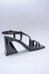Sandalia negra de tacón con punta cuadrada y tiras finas cruzadas en el empeine.