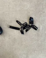 Botín de cuero vacuno negro de caña corta con hebilla y tachas plateadas.