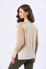 Buzo tejido de abrigo con bloques de color en rosa, beige y gris claro. Tiene cuello redondo y mangas largas.