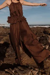 Pantalón negro de corte amplio con pinzas en la cintura, regulable con elástico y tiras.