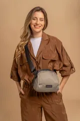 Bandolera pequeña de tela negra, con correa ancha ajustable y cierre superior.