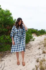 Túnica de corte amplio con estampado de cuadros azules y blancos, cuello redondo y mangas 3/4. Incluye cinturón de la misma tela.