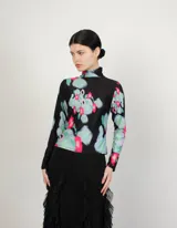 Polera de cuello alto y mangas largas, confeccionada en tela sublimada con estampado abstracto en tonos negro, azul, verde y rosa.