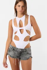 Body blanco de microfibra con aberturas y piezas superpuestas en el delantero y espalda. Diseño musculosa sin mangas, cuello redondo y detalle de chapita TE en la espalda. Cierre con broches snap en la entrepierna y elástico interno en el tiro y bordes para mejor ajuste.