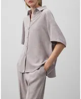 Camisa oversize color gris con manga corta japonesa sobre el codo, cuello solapa y botonadura frontal.